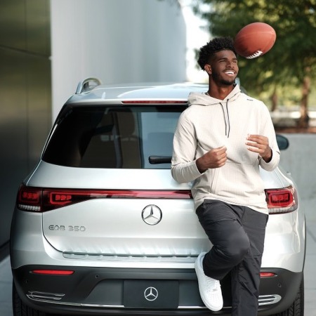 Shedeur James posing in Mercedes Benz EQC.